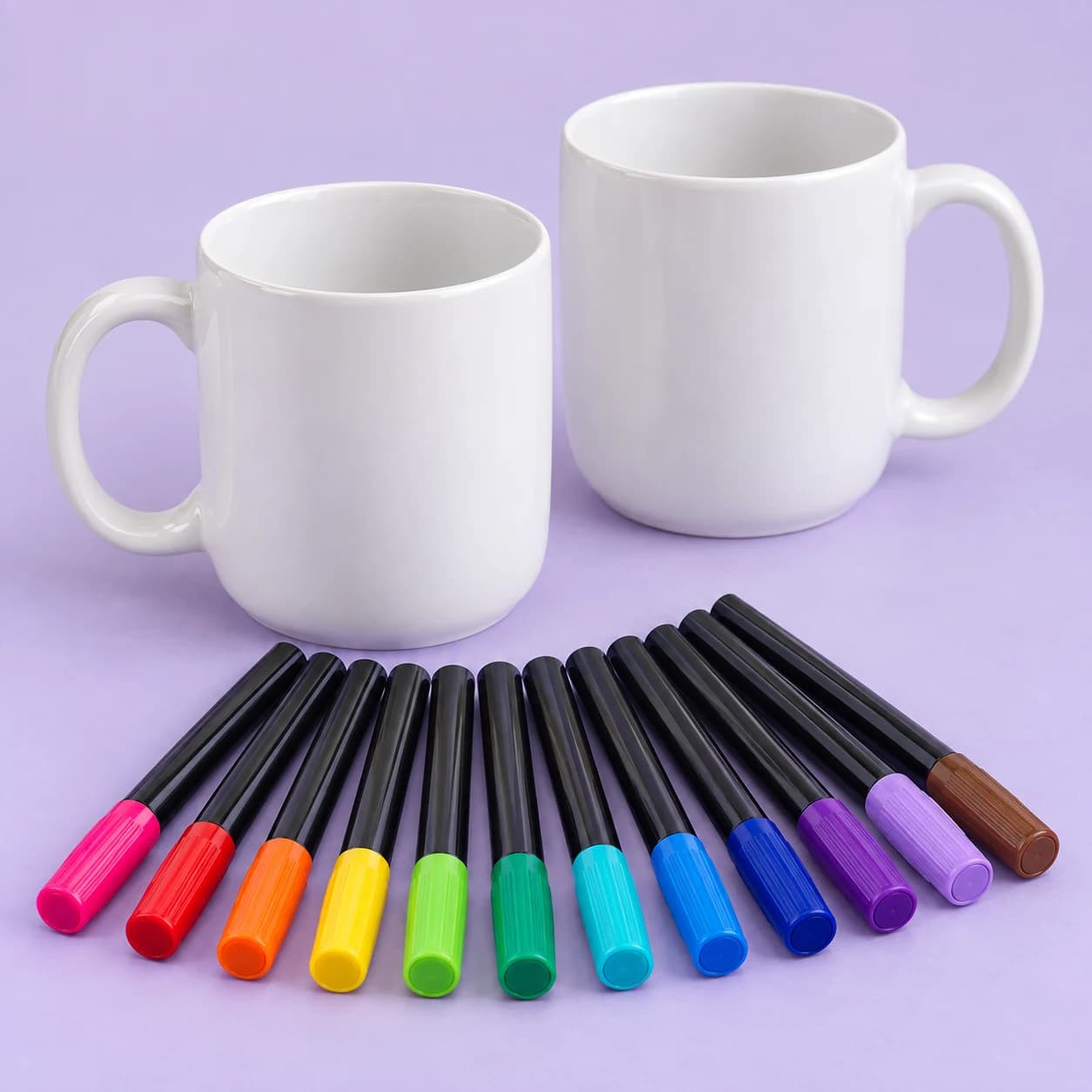 Two blank ceramic mugs and twelve colourful porcelain markers